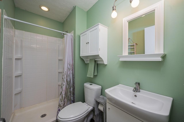 bathroom with vanity, a textured ceiling, toilet, and a shower stall