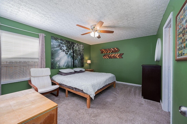 carpeted bedroom featuring a ceiling fan and a textured ceiling
