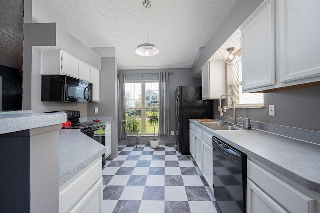 kitchen featuring a sink, light countertops, white cabinets, and black appliances