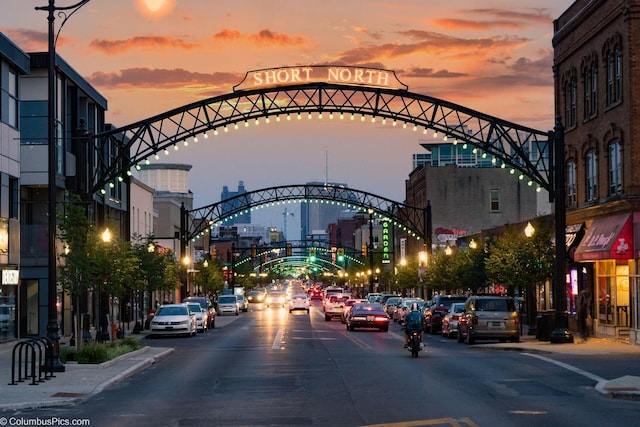 view of street featuring curbs, a city view, street lights, and sidewalks
