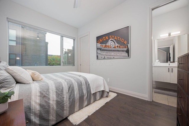 bedroom featuring connected bathroom, baseboards, and dark wood-style floors