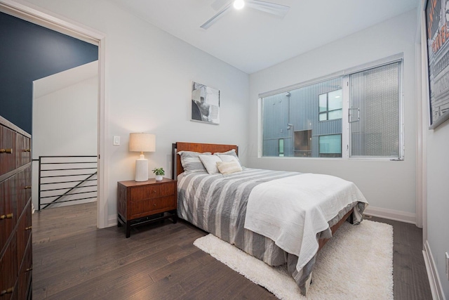 bedroom featuring baseboards, ceiling fan, and dark wood finished floors