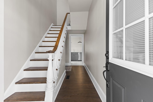 stairway featuring baseboards, wood-type flooring, and visible vents