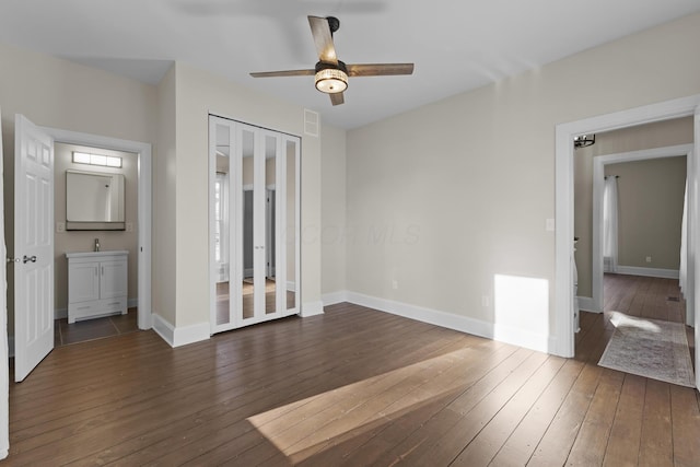 unfurnished bedroom with baseboards, a ceiling fan, and dark wood-style floors