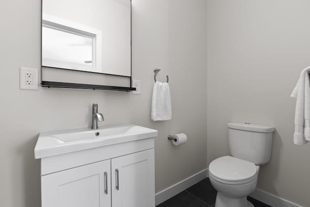 half bath with toilet, baseboards, tile patterned floors, and vanity