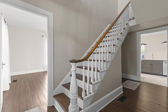 stairs with baseboards, hardwood / wood-style floors, and visible vents