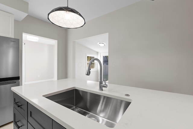 details featuring a sink and freestanding refrigerator