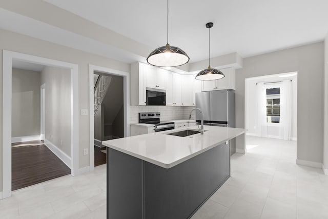 kitchen with light countertops, white cabinetry, a sink, backsplash, and stainless steel appliances