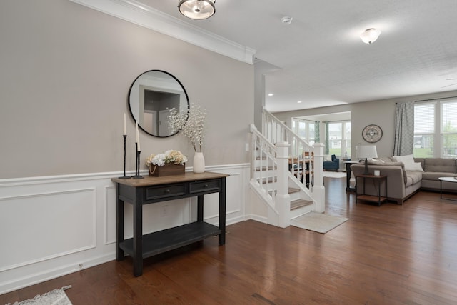 interior space with crown molding, wainscoting, wood finished floors, a decorative wall, and stairs