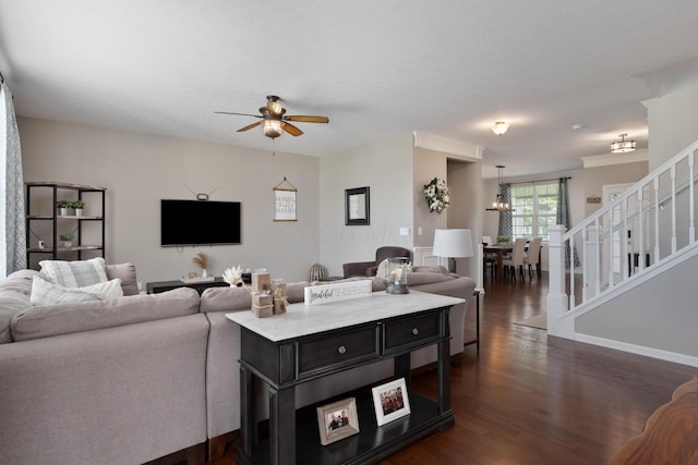 living room with baseboards, ceiling fan with notable chandelier, dark wood finished floors, and stairs
