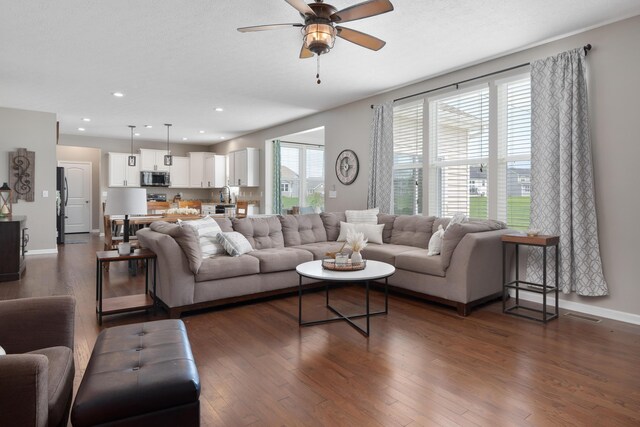 living area with visible vents, a ceiling fan, dark wood-style floors, and recessed lighting