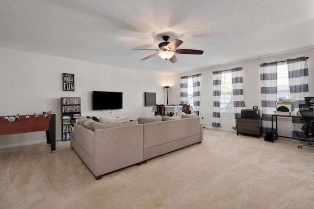 carpeted living area featuring a textured ceiling, ceiling fan, and baseboards