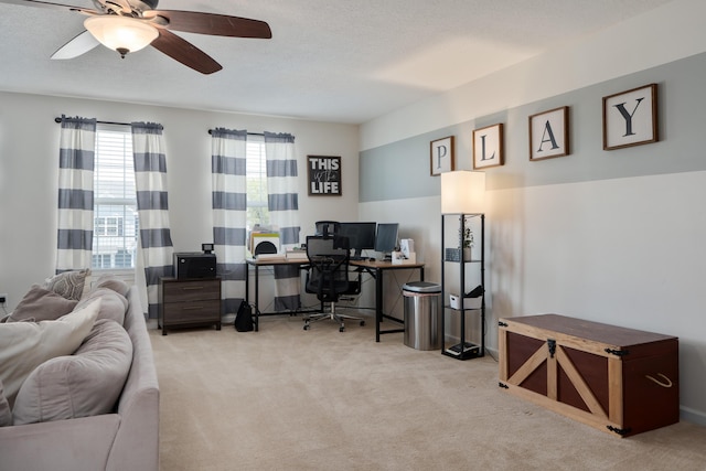 carpeted home office featuring a ceiling fan