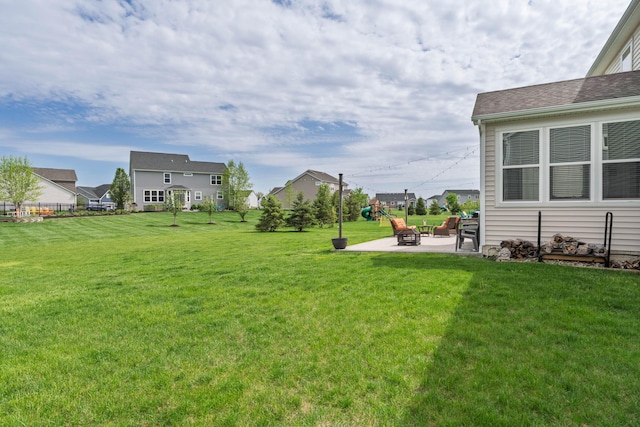 view of yard featuring a playground, a patio area, and a residential view