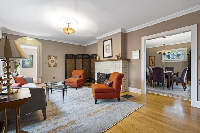 47 Richards Rd, Columbus, OH 43214 - sitting room featuring a brick fireplace, baseboards, wood finished floors, visible vents, and ornamental molding