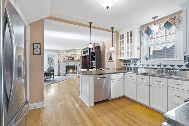 47 Richards Rd, Columbus, OH 43214 - kitchen featuring stainless steel countertops, appliances with stainless steel finishes, light wood-type flooring, a sink, and white cabinetry
