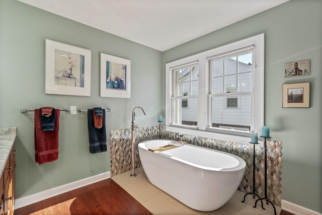 47 Richards Rd, Columbus, OH 43214 - full bathroom featuring baseboards, a freestanding tub, wood finished floors, and vanity
