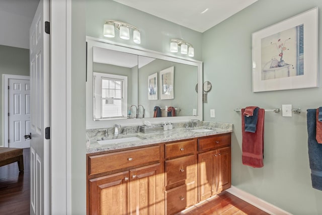 47 Richards Rd, Columbus, OH 43214 - bathroom with a sink, baseboards, double vanity, and wood finished floors