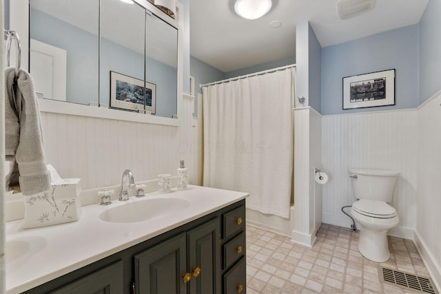 47 Richards Rd, Columbus, OH 43214 - bathroom featuring wainscoting, vanity, tile patterned floors, toilet, and shower / bathtub combination with curtain