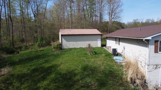 view of yard featuring central AC unit and an outdoor structure