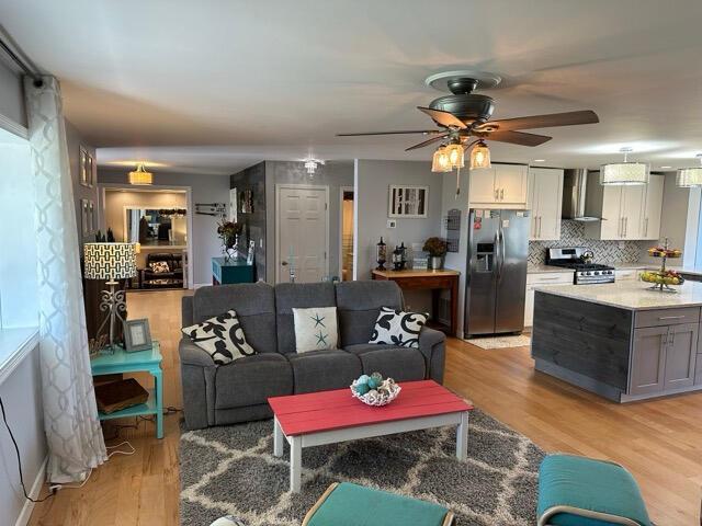 living room with ceiling fan and light wood-style floors