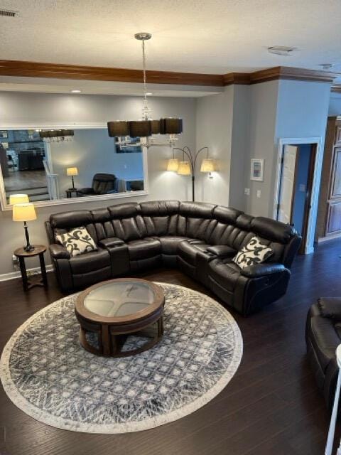 living room with crown molding, wood finished floors, and visible vents