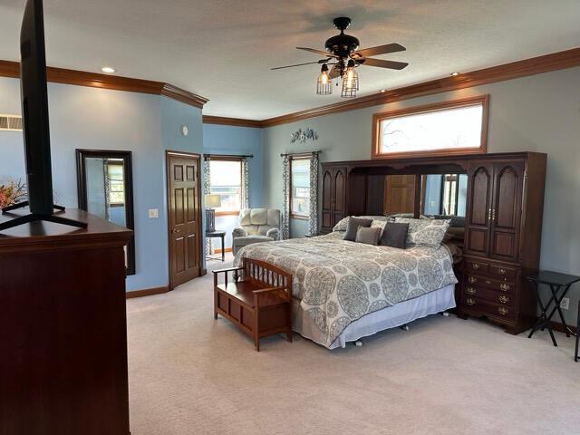 bedroom featuring ceiling fan, light colored carpet, ornamental molding, and baseboards