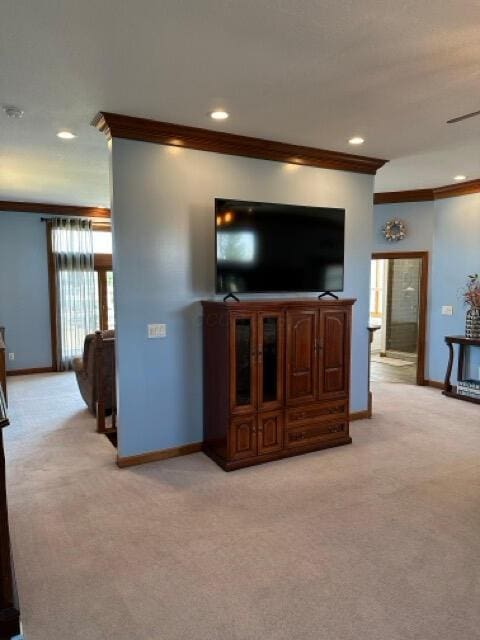 living area with baseboards and light colored carpet