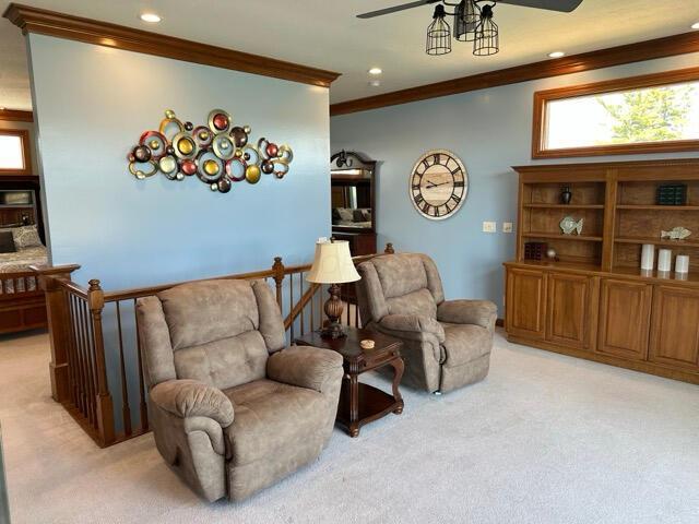 sitting room with crown molding, recessed lighting, ceiling fan, and light colored carpet