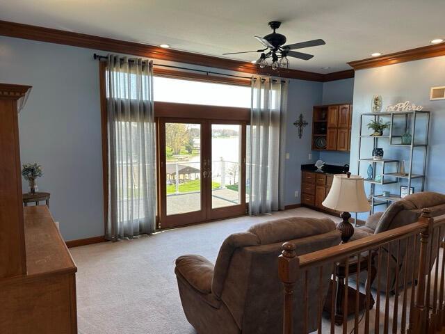 living room with baseboards, ornamental molding, light carpet, and french doors