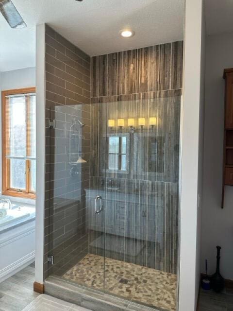 bathroom featuring recessed lighting, a shower stall, wood finished floors, and a bath