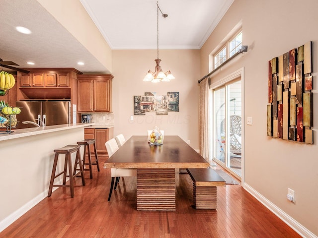 dining room with dark wood-style flooring, baseboards, a chandelier, ornamental molding, and recessed lighting