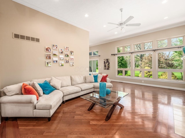 living room featuring crown molding, a wealth of natural light, visible vents, and recessed lighting