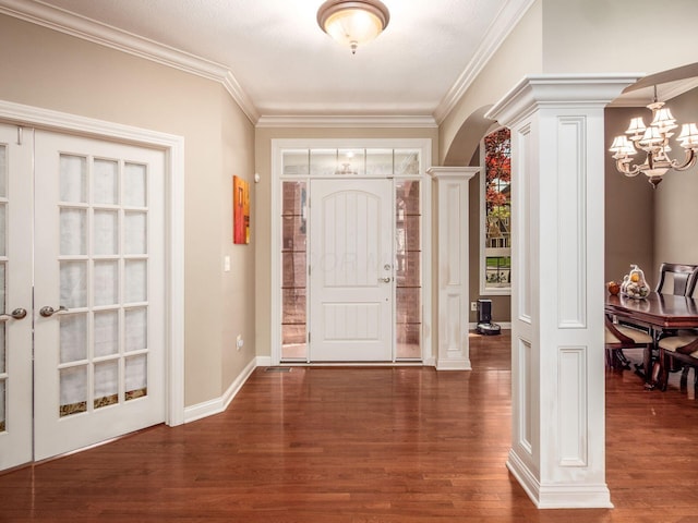 entrance foyer featuring an inviting chandelier, crown molding, arched walkways, and wood finished floors