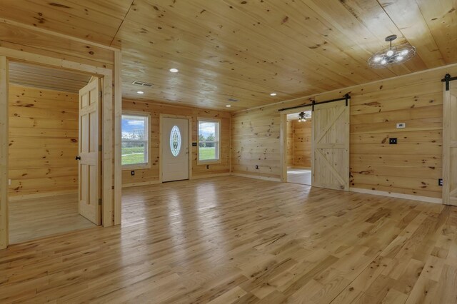 7435 Baltimore Somerset Rd NE, Thornville, OH 43076 - additional living space featuring wood ceiling, visible vents, a barn door, wooden walls, and light wood-style floors