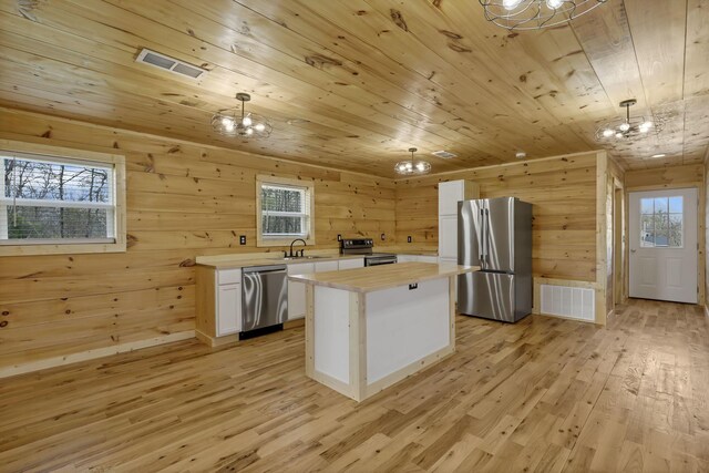 7435 Baltimore Somerset Rd NE, Thornville, OH 43076 - kitchen featuring an inviting chandelier, butcher block countertops, appliances with stainless steel finishes, and wood walls