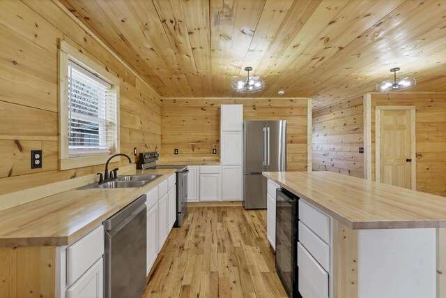 7435 Baltimore Somerset Rd NE, Thornville, OH 43076 - kitchen with appliances with stainless steel finishes, wine cooler, a sink, wooden walls, and butcher block countertops