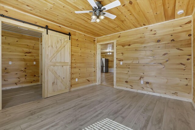 7435 Baltimore Somerset Rd NE, Thornville, OH 43076 - spare room with a ceiling fan, a barn door, wood ceiling, and wood finished floors