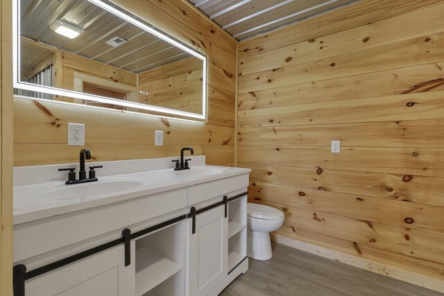 7435 Baltimore Somerset Rd NE, Thornville, OH 43076 - bathroom featuring a sink, double vanity, toilet, and wood finished floors