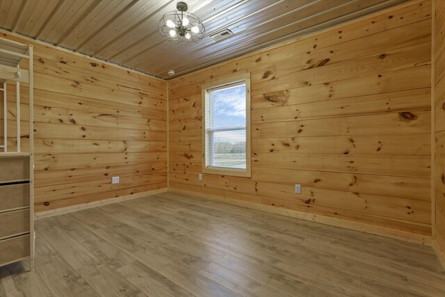 7435 Baltimore Somerset Rd NE, Thornville, OH 43076 - unfurnished room with a notable chandelier, wood walls, baseboards, wooden ceiling, and wood finished floors