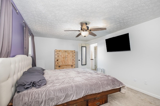 bedroom with a ceiling fan, baseboards, carpet, and a textured ceiling