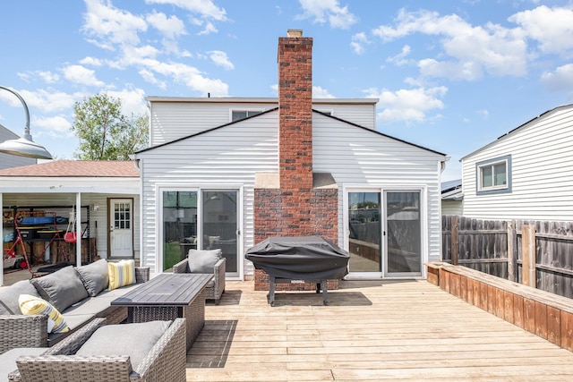 wooden deck with grilling area, fence, and an outdoor hangout area
