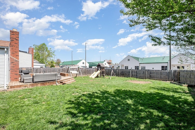 view of yard featuring an outdoor living space, a fenced backyard, a playground, and a deck