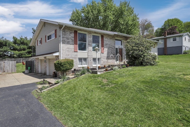 view of front of house with a garage, a front lawn, fence, brick siding, and driveway