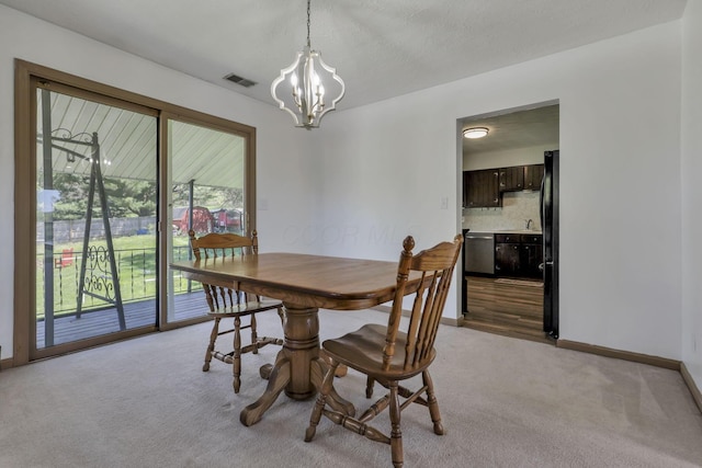 dining area featuring light colored carpet, baseboards, a chandelier, and visible vents