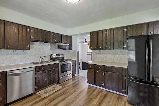 kitchen featuring backsplash, a sink, appliances with stainless steel finishes, and dark brown cabinetry