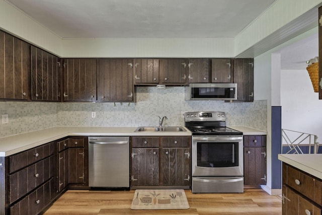 kitchen featuring a sink, appliances with stainless steel finishes, dark brown cabinetry, and light wood-type flooring