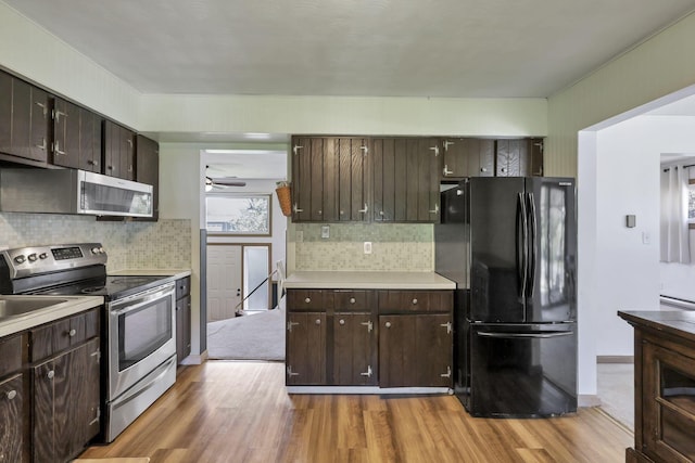 kitchen featuring light wood-style floors, dark brown cabinetry, and stainless steel appliances