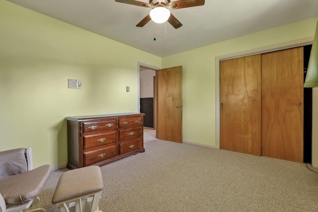 carpeted bedroom featuring a closet, baseboards, and ceiling fan