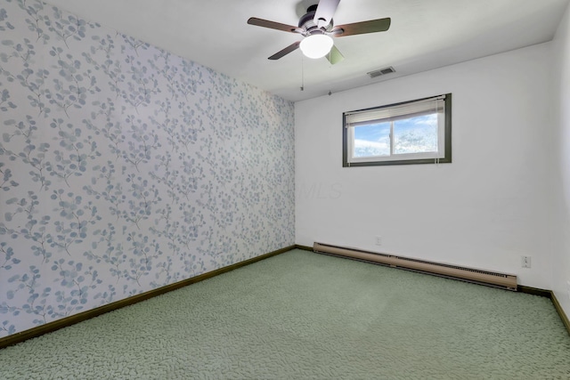 carpeted empty room with visible vents, a ceiling fan, a baseboard heating unit, and wallpapered walls